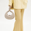 Ivory Luna Bag with crescent shape and top handle, made of full-grain leather.