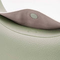 Mint green pebbled leather Luna Bag interior flap with grey suede lining and magnetic snap closure.
