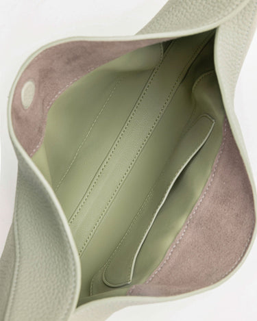 Interior of the Luna Bag showing sage green leather lining with subtle stitching and an open pocket.