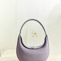 Lavender Luna Bag: Full-grain leather handbag with silver hardware and crescent shape, featuring dragonfly accent.