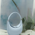 Sky blue Luna Bag, full-grain leather, silver hardware, curved strap, magnetic closure. Elegant and versatile.
