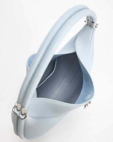 Sky blue Luna Bag made of full-grain leather with a synthetic interior, featuring a rounded handle and silver hardware.