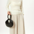 Luna Bag (vegan leather) in Eco Onyx, a black textured handbag with gold clasp.