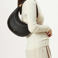 Luna Bag (vegan leather) in Eco Onyx worn on the shoulder by a model. Vegan leather, gold hardware.