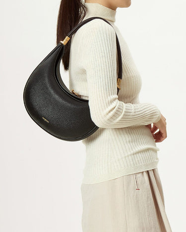 Luna Bag (vegan leather) in Eco Onyx worn on the shoulder by a model. Vegan leather, gold hardware.