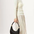 Black vegan leather Luna bag with gold hardware, crescent shape, textured finish, and 'Songmont' embossing.