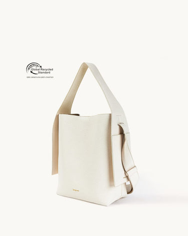 Cream vegan leather tote bag with adjustable strap and Global Recycled Standard certification.
