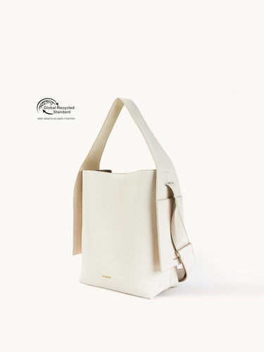 Cream vegan leather tote bag with adjustable strap and Global Recycled Standard certification.