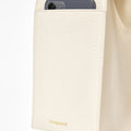 Cream vegan leather tote bag with exterior phone pocket featuring the Songmont logo.