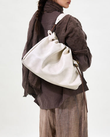 Medium Gather Bag Set in Cloud white Nappa leather with adjustable straps, worn by a model.