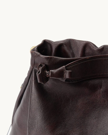 Medium Gather Bag Set in rich, textured brown leather with gathered opening and knot detail.