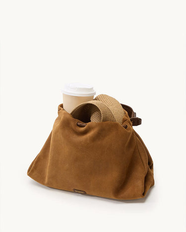 Ochre suede medium gather bag set with coffee cup and straw hat, featuring leather accents and Songmont logo.