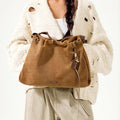Ochre Suede Medium Gather Bag Set with drawstring, leather charm, and braided straps.