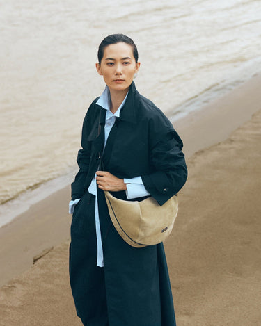 Large Luna Hobo Bag in Dune Suede on a woman by the ocean