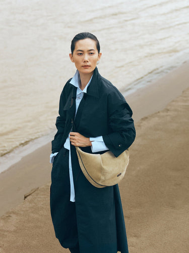 Large Luna Hobo Bag in Dune Suede on a woman by the ocean