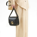 Medium Reset Tofu Bag in Onyx, a structured black calf leather crossbody bag with gold hardware.
