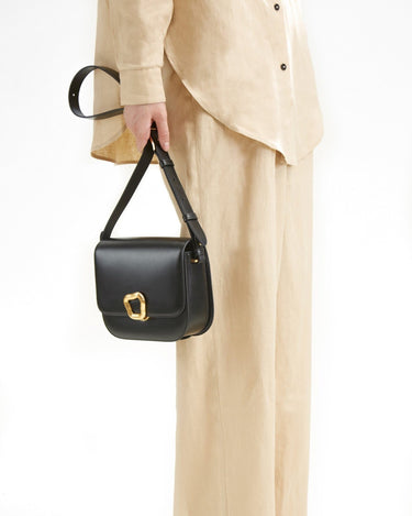 Medium Reset Tofu Bag in Onyx, a structured black calf leather crossbody bag with gold hardware.