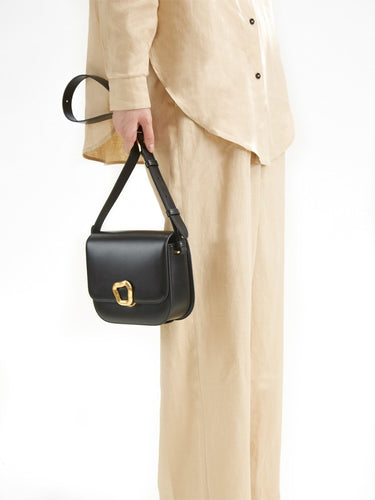 Medium Reset Tofu Bag in Onyx, a structured black calf leather crossbody bag with gold hardware.
