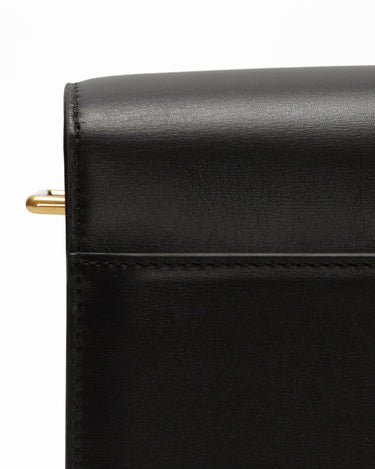 Close-up of a black leather Medium Reset Tofu Bag showing stitching detail and a gold ring.