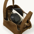 Medium Song Bag in Agarwood Nubuck leather, with phone and black headphones inside