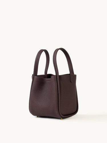 Medium burgundy Song Bag crafted from full-grain leather with a structured base and dual top handles.