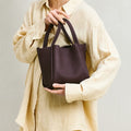 Medium burgundy Song bag in pebbled full-grain leather with top handles. Versatile design for work and travel.