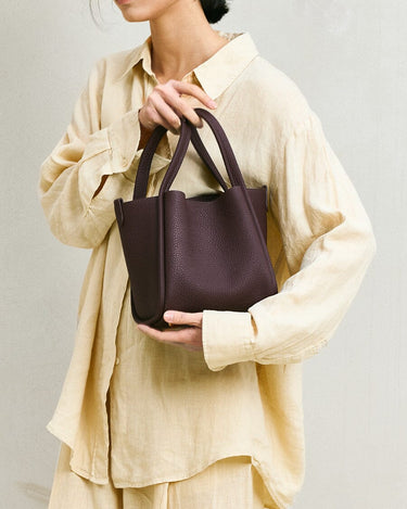 Medium burgundy Song bag in pebbled full-grain leather with top handles. Versatile design for work and travel.