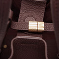 Medium Song Bag burgundy leather interior with brass closure and embossed Songmont logo.