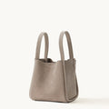 Medium Song Bag in Haze nubuck leather, structured O-shape design with dual top handles.
