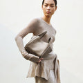 Medium Song Bag in Haze nubuck leather, with top handles and a structured design, held by a model.