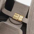 Medium Song Bag in Haze nubuck leather with gold magnetic clasp and embossed Songmont logo.