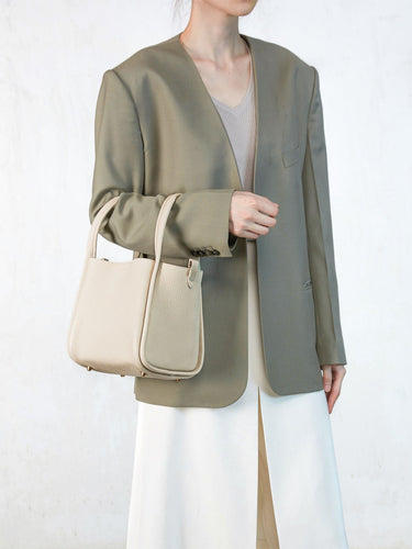 Ivory pebbled leather Medium Song Bag with single handle and flap closure. Chic everyday style.