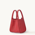 Medium Song Bag in Lucky Red full-grain leather, a structured bucket bag with dual top handles and protective metal feet.