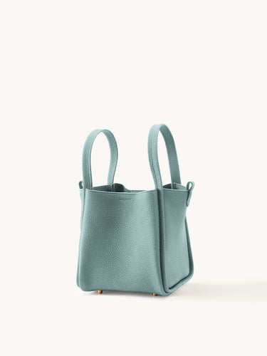 Mint green full-grain leather medium song bag with top handles and magnetic closure
