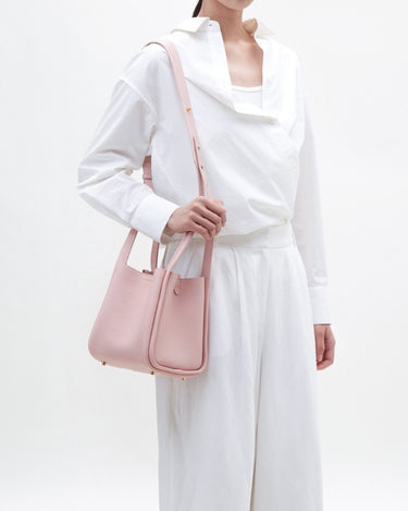 Medium Song Bag in Pink: A pebble leather bucket bag with a top handle and adjustable strap, perfect for everyday elegance.