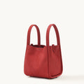 Medium Song Bag in Lucky Red pebbled leather, with top handles and gold feet.