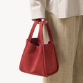 Medium Song Bag in vibrant Poppy red nubuck leather with a unique O-shaped structure and twin top handles.