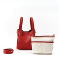 Red Songmont Medium Bag with ivory canvas inner pouch and red strap, showcasing nubuck texture.
