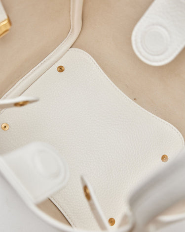 Close-up of the interior of a white vegan leather Medium Song Bag, showing textured material and gold-tone hardware.