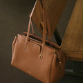 Golden Brown Medium Yore Duffle Bag: Full-grain leather, white stitching, gold hardware.