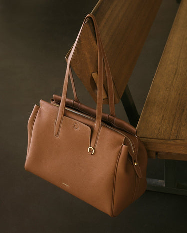 Golden Brown Medium Yore Duffle Bag: Full-grain leather, white stitching, gold hardware.