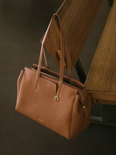 Golden Brown Medium Yore Duffle Bag: Full-grain leather, white stitching, gold hardware.