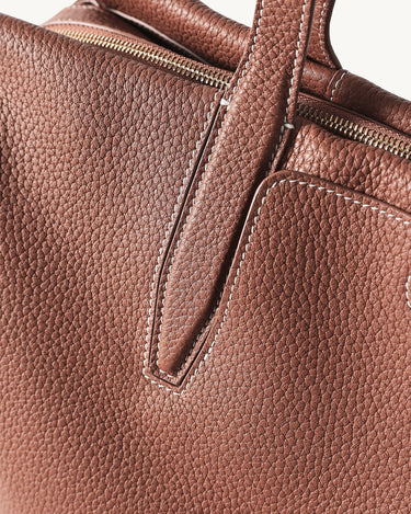 Medium Yore Duffle Bag in Golden Brown full-grain leather with contrast stitching and brass zippers.