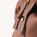 Medium Yore Duffle Bag in Golden Brown full-grain leather with gold hardware and white stitching.