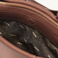 Medium Yore Duffle Bag interior, golden brown full-grain leather, white stitching, gold zipper, abstract wave lining