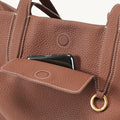 Golden Brown Medium Yore Duffle Bag: Textured full-grain leather, white stitching, gold hardware, front phone pocket.