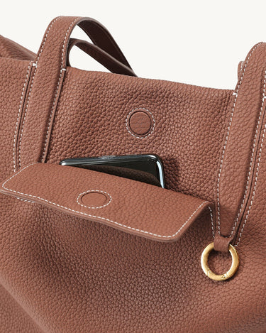 Golden Brown Medium Yore Duffle Bag: Textured full-grain leather, white stitching, gold hardware, front phone pocket.