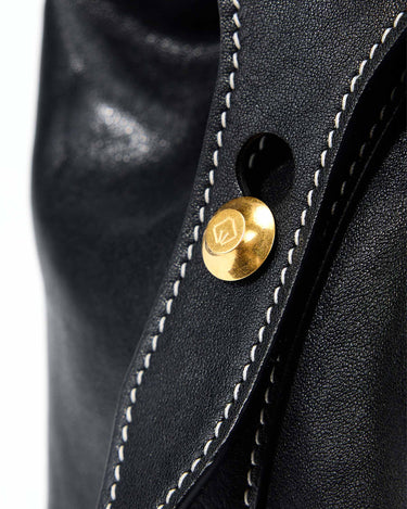 Medium Yore Duffle Bag in Onyx black leather with white contrast stitching and gold hardware detail.