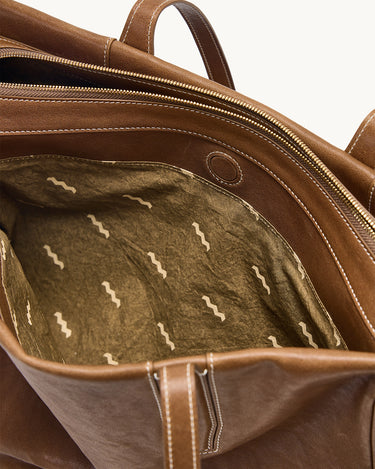 Brown leather Medium Yore Duffle Bag interior with unique patterned lining and open main compartment.