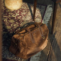 Medium Yore Duffle Bag in Sandal Suede with tan leather trim and white stitching, a stylish travel companion.